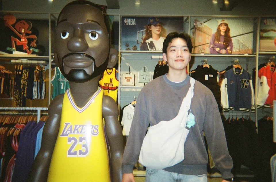 Austin Chen beside a LeBron James figure in an NBA store